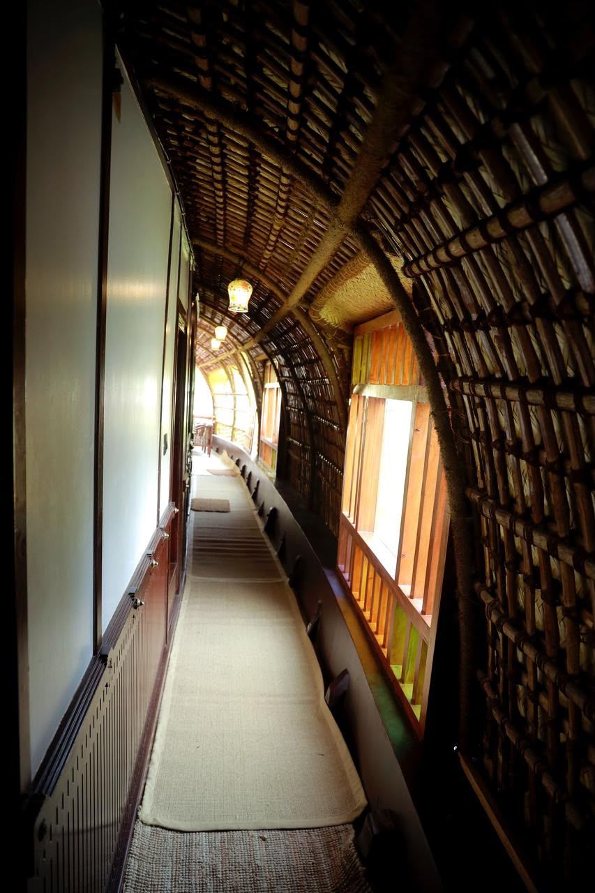 Narrow corridor running along the side of the boat under an arched bamboo and coir roof