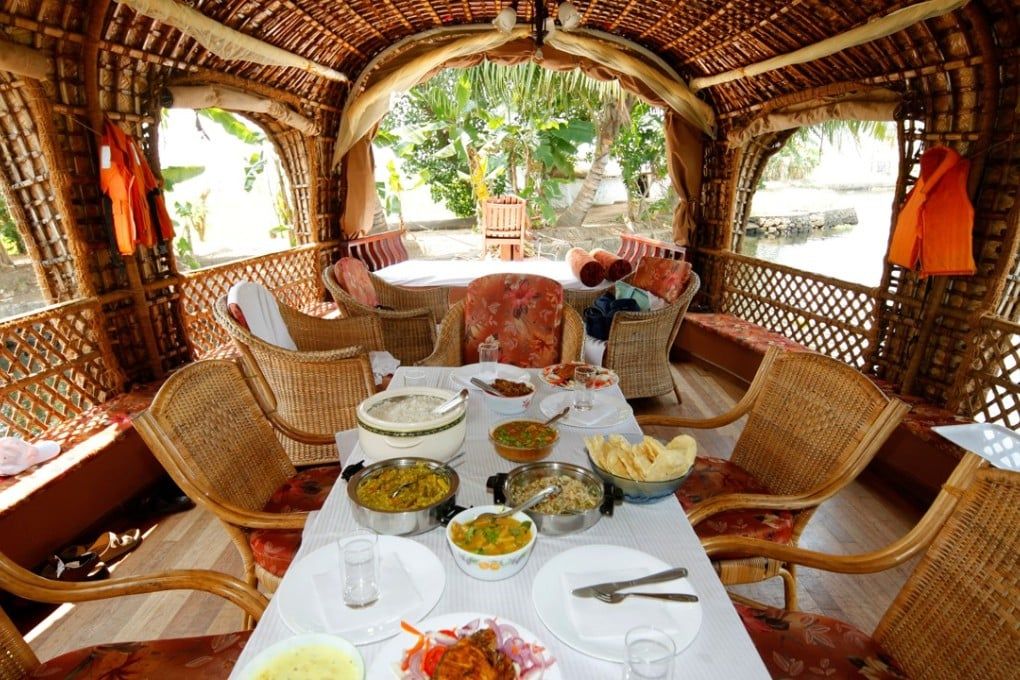 Table set on a houseboat deck with rice, curries, papadum and fried fish